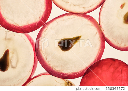 Grape slices with their red skin, translucent pulp, and visible seeds in close-up 138363572