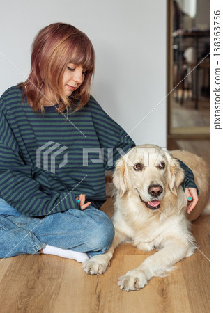 Young girl enjoying time with her golden retriever dog 138363756