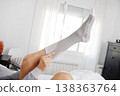 a man checks a compression sock on his leg 138363764