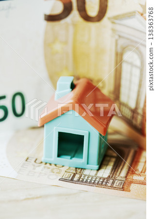 a toy house placed over a euro banknote a toy house placed over a euro banknote 138363768