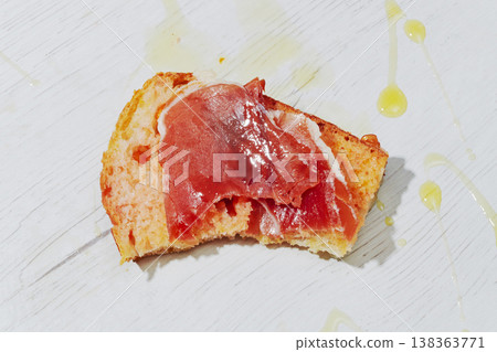 a bitten slice of pa amb tomaquet with ham 138363771
