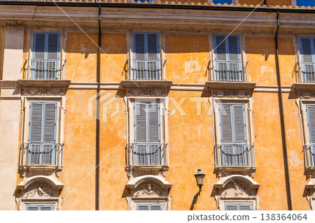 Italy Rome street orange house facade. Old historical building architecture in the city center. Italian windows with shutters. Italy Rome street orange house facade. Old historical building architecture in the city center. Italian windows with shutters. 138364064