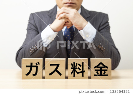 A block with "Gas Charges" written on it and a businessman A block with "Gas Charges" written on it and a businessman 138364331