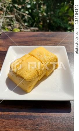 陽光下，一塊看起來美味可口的厚蛋捲——日式便當盒裡的必備佳餚。 138364342