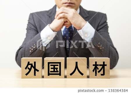 一塊標有「外籍人才」的方塊和一個商人 一塊標有「外籍人才」的方塊和一個商人 138364384