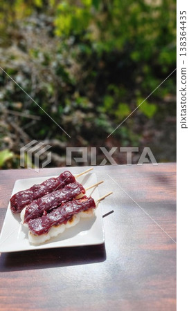Enjoying springtime Japanese sweets, such as anko dango (sweet bean paste dumplings), outdoors in the warm sunshine. Enjoying springtime Japanese sweets, such as anko dango (sweet bean paste dumplings), outdoors in the warm sunshine. 138364435