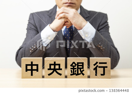 A block with the words "Central Bank" written on it and a businessman A block with the words "Central Bank" written on it and a businessman 138364448