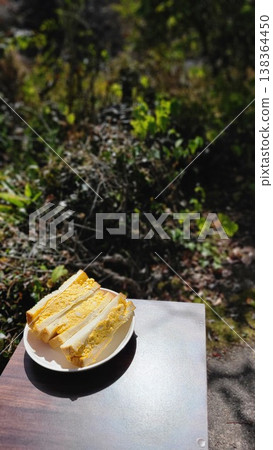 Enjoy a thick-cut egg sandwich outdoors in the dappled sunlight. Enjoy a thick-cut egg sandwich outdoors in the dappled sunlight. 138364450