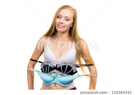 Woman holds bras, choosing Woman holds bras, choosing 138364591
