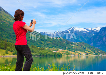 Tourist taking photo at norwegian fjord Tourist taking photo at norwegian fjord 138364847