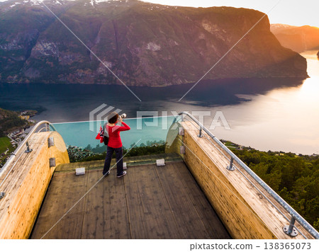 Tourist enjoying fjord view on Stegastein viewpoint Norway Tourist enjoying fjord view on Stegastein viewpoint Norway 138365073