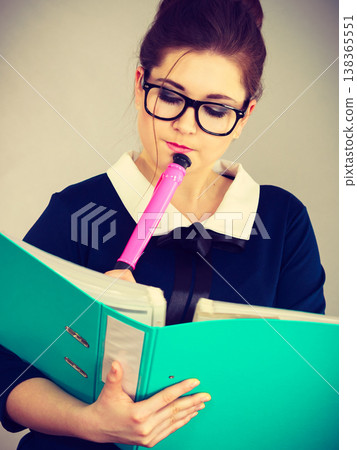 woman thinking holds file folder with documents woman thinking holds file folder with documents 138365551