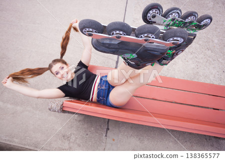 Crazy woman on bench wearing roller skates Crazy woman on bench wearing roller skates 138365577