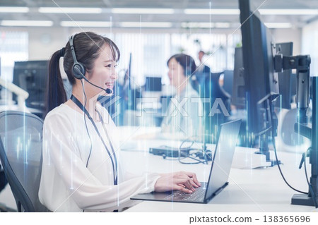 A smiling woman assisting customers at a call center. 138365696