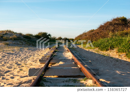 Old Train Tracks on a Sandy Beach Leading to the Horizon Old Train Tracks on a Sandy Beach Leading to the Horizon 138365727