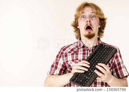 Gamer man holding computer keyboard 138365790
