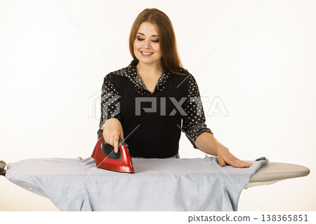 Happy woman doing ironing Happy woman doing ironing 138365851