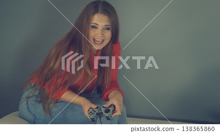 Young woman playing video games Young woman playing video games 138365860