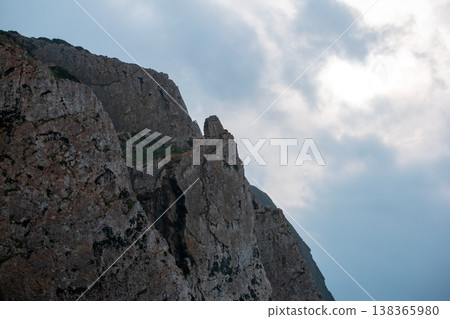 Rocky Coastal Cliff Under Overcast Sky in Nature 138365980