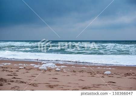 Waves Crashing on a Sandy Beach Below a Cliff with Yellow Flowers Waves Crashing on a Sandy Beach Below a Cliff with Yellow Flowers 138366047