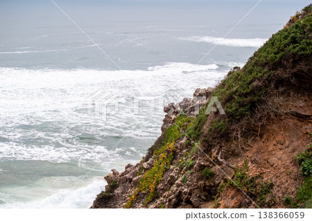Scenic Beach with Waves Crashing Under a Cliff Scenic Beach with Waves Crashing Under a Cliff 138366059