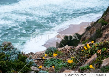 Sea Waves Crashing Against Rocky Cliff on a Sandy Beach Sea Waves Crashing Against Rocky Cliff on a Sandy Beach 138366061