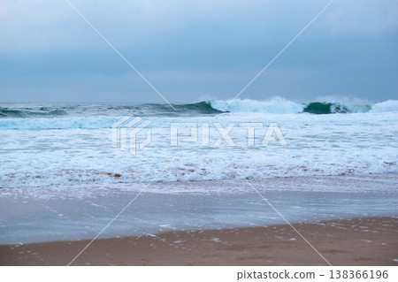 Beach with Ocean Waves Rolling Against Rocky Cliff Beach with Ocean Waves Rolling Against Rocky Cliff 138366196