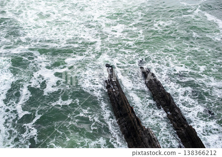 Ocean Waves Hitting Cliff with Sandy Beach Foreground Ocean Waves Hitting Cliff with Sandy Beach Foreground 138366212