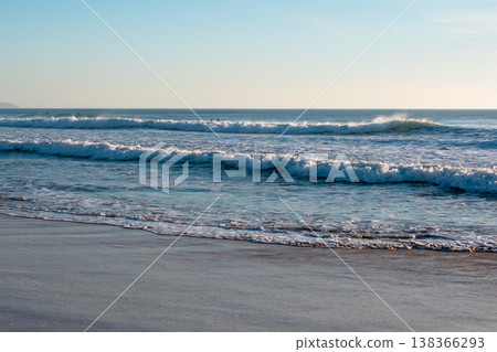 Cloudy day at a rugged beach with cliffs and ocean waves 138366293