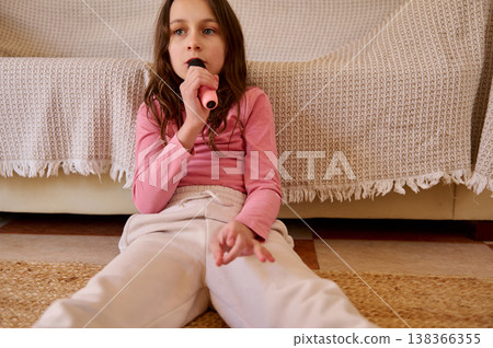 Young Girl Singing With Microphone At Home Sitting On Living Room Floor Young Girl Singing With Microphone At Home Sitting On Living Room Floor 138366355