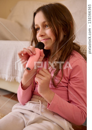 Young Girl Singing With Pink Microphone at Home Sofa Karaoke Session Young Girl Singing With Pink Microphone at Home Sofa Karaoke Session 138366365