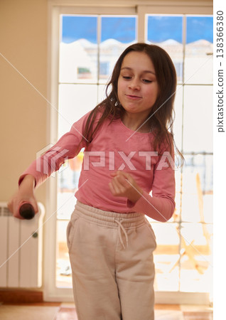 Young Girl Playing With Toy Microphone Indoors In Pink Top And Beige Sweatpants Young Girl Playing With Toy Microphone Indoors In Pink Top And Beige Sweatpants 138366380