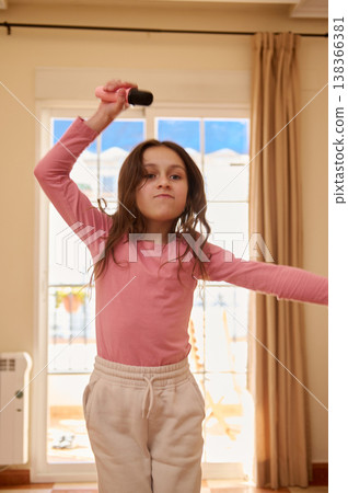 Young Girl Singing With Microphone In Living Room Having Fun And Expressive Play At Home Young Girl Singing With Microphone In Living Room Having Fun And Expressive Play At Home 138366381
