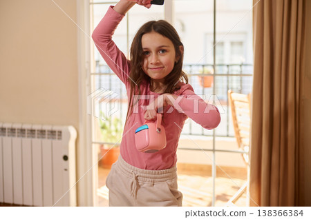 Young Girl Playing With Pink Portable Speaker By Sunlit Balcony Door Young Girl Playing With Pink Portable Speaker By Sunlit Balcony Door 138366384