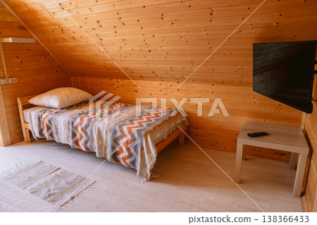 Cozy attic bedroom with wooden walls, bed and tv in hostel Cozy attic bedroom with wooden walls, bed and tv in hostel 138366433