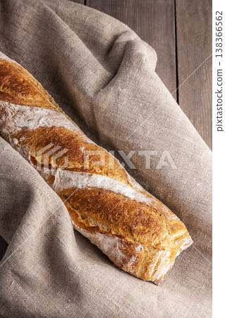 Freshly baked french baguette in on wooden background. High quality photo Freshly baked french baguette in on wooden background. High quality photo 138366562