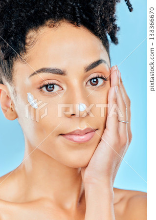 Beauty skincare, portrait and woman with cream dermatology product for melasma, acne or sunscreen protection. Face makeup, studio cosmetics or person feel pimple prevention results on blue background Beauty skincare, portrait and woman with cream dermatology product for melasma, acne or sunscreen protection. Face makeup, studio cosmetics or person feel pimple prevention results on blue background 138366670