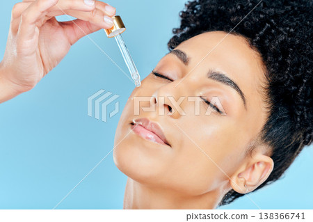 Beauty, relax face and woman with serum application for skin hydration, anti aging and collagen essential oil liquid for skincare. Retinol dropper, hyaluronic acid or studio person on blue background Beauty, relax face and woman with serum application for skin hydration, anti aging and collagen essential oil liquid for skincare. Retinol dropper, hyaluronic acid or studio person on blue background 138366741