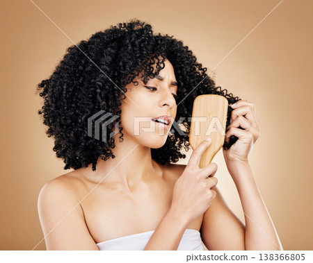 Hair, frustrated and woman with afro brush for style isolated in a studio brown background for wellness and skincare. Comb, knots and confused person with cosmetic aesthetic in Brazil hairdresser Hair, frustrated and woman with afro brush for style isolated in a studio brown background for wellness and skincare. Comb, knots and confused person with cosmetic aesthetic in Brazil hairdresser 138366805