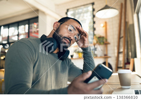 Man, phone and headache in coffee shop for remote work, job search or bad news of financial fail, debt or loan. African person with stress, worry or confused reading information on his mobile at cafe Man, phone and headache in coffee shop for remote work, job search or bad news of financial fail, debt or loan. African person with stress, worry or confused reading information on his mobile at cafe 138366810