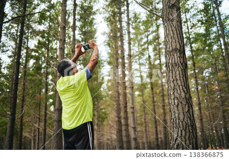 Man, phone photography and trees in woods for art, social media post or memory on walk, hiking or adventure. Senior photographer, back and smartphone for nature, sustainable forest and countryside 138366875