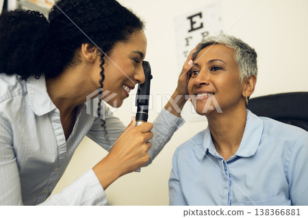 Woman, eyes and healthcare in clinic with ophthalmoscope to check glaucoma, ocular services or expert consultation. Optometrist, retina analysis and eye exam of happy mature patient with vision tools 138366881