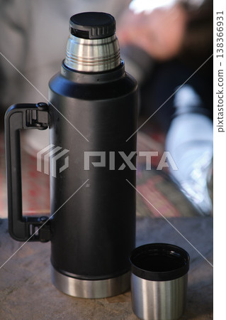 a black thermos on the table outdoor a black thermos on the table outdoor 138366931