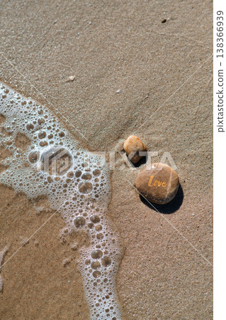 a stone with the inscription love on the coastal sand a stone with the inscription love on the coastal sand 138366939