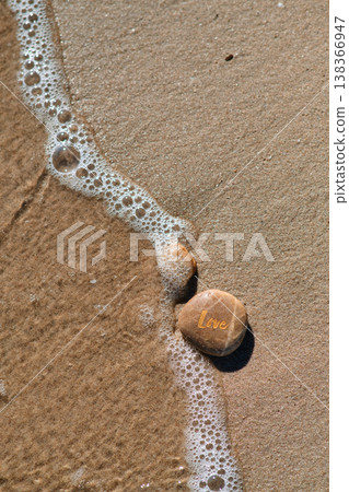 a stone with the inscription love on the coastal sand a stone with the inscription love on the coastal sand 138366947