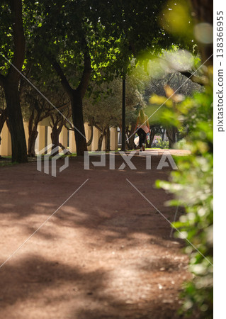 In a green city park, people running along the path In a green city park, people running along the path 138366955