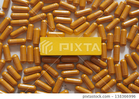 Warm yellow wooden plate on a vivid macro layer of glossy curcumin capsules, creating bold contrast and a strong branding focal point for modern wellness, supplements and natural health visuals Warm yellow wooden plate on a vivid macro layer of glossy curcumin capsules, creating bold contrast and a strong branding focal point for modern wellness, supplements and natural health visuals 138366996