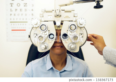 Woman, eye exam and phoropter with optometrist hand, check and lens for vision, wellness and health in clinic. Doctor, eyesight tools and machine for assessment, consultation and glasses in hospital Woman, eye exam and phoropter with optometrist hand, check and lens for vision, wellness and health in clinic. Doctor, eyesight tools and machine for assessment, consultation and glasses in hospital 138367173