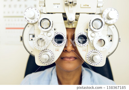 Eye test, face or woman consulting to help eyesight at optometrist for a optical assessment. Optometry, wellness or customer in clinic for vision, iris or retina health with machine or phoropter Eye test, face or woman consulting to help eyesight at optometrist for a optical assessment. Optometry, wellness or customer in clinic for vision, iris or retina health with machine or phoropter 138367185
