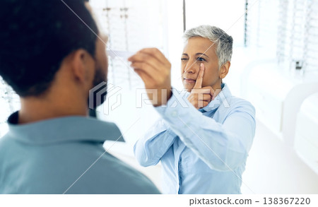 Vision, eyes and medical test with a man at the optometrist for prescription diagnosis or assessment. Distance, measure or exam with a customer talking to a consultant at the optician for assistanc 138367220